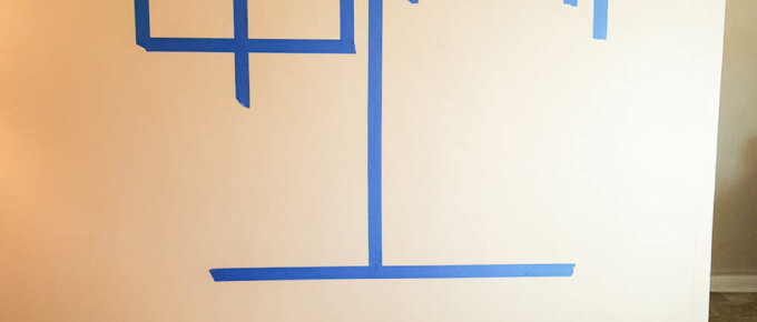 A wall marked out with blue tape before hanging